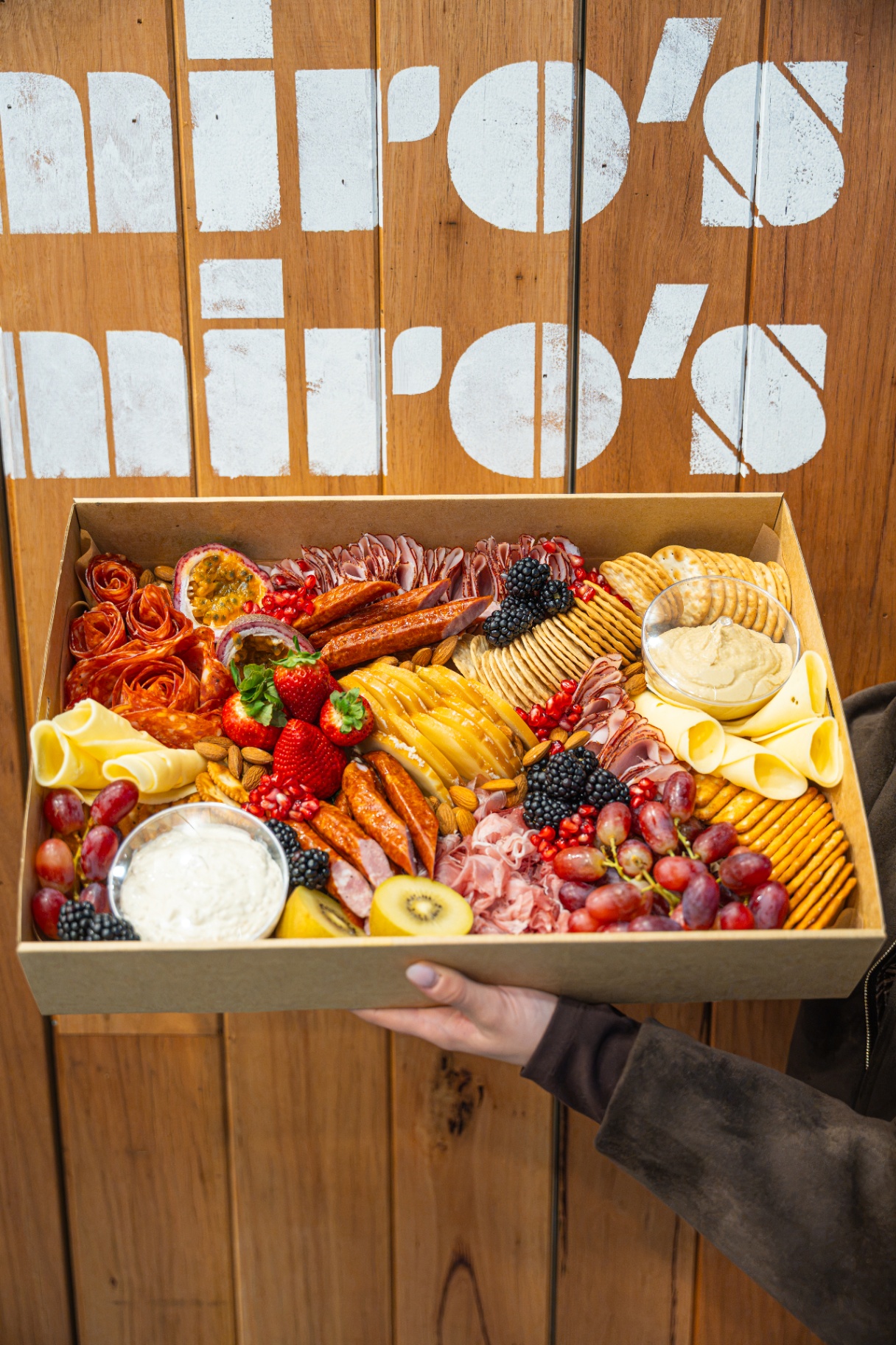 A Miro's Deli grazing box with cured meats, cheeses, crackers and fruit