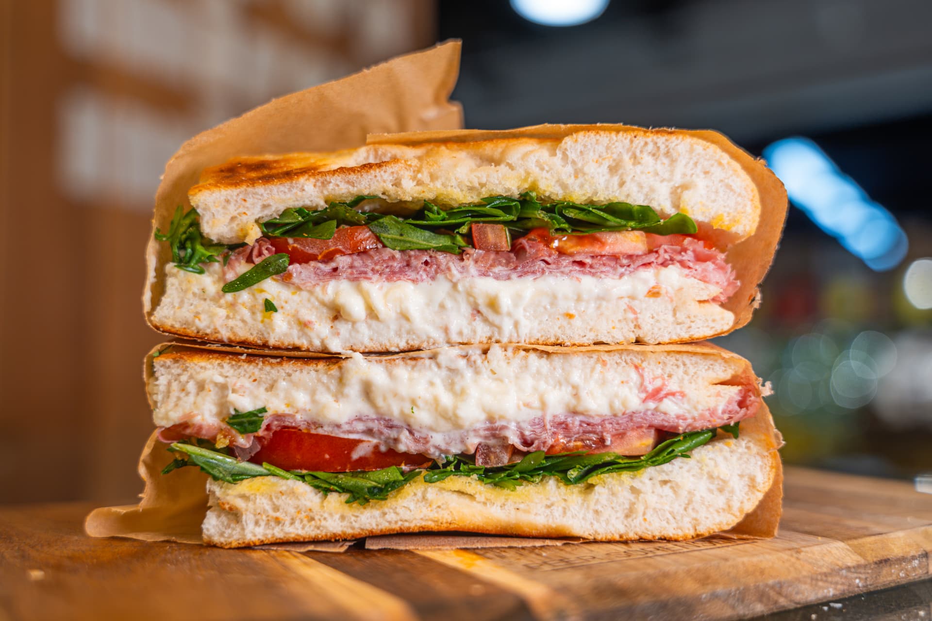 Signature Prosciutto focaccia sandwich stacked and wrapped.